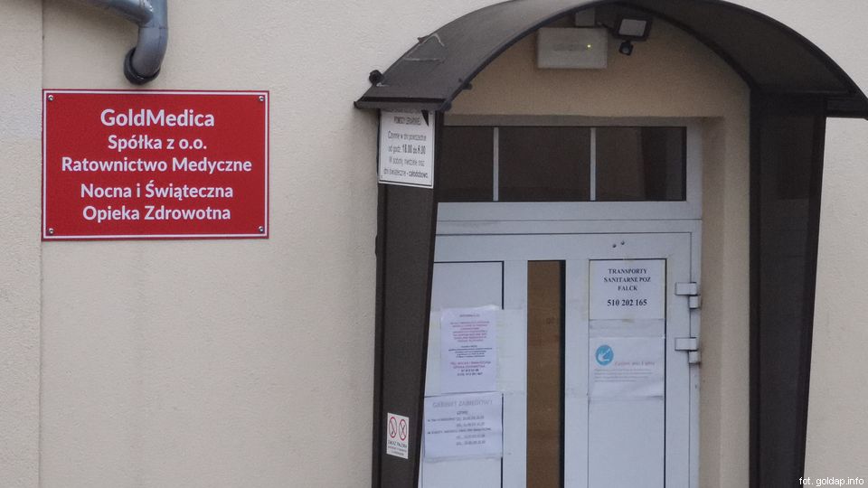 zdjęcie z drzwi wejściowych do pogotowia w Gołdapi i tablicy informacyjnej 